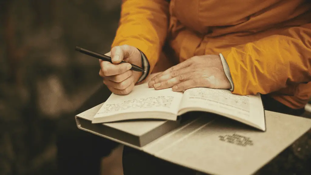 woman in a yellow jacket writing in a garden journal